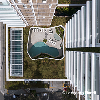 Fachada do edifício AYRA, da construtora SKR, repleta de vidro nas janelas. Há quatro pavimentos mais largos sobre o térreo. Do quinto pavimento em diante, está a torre, de largura menor.