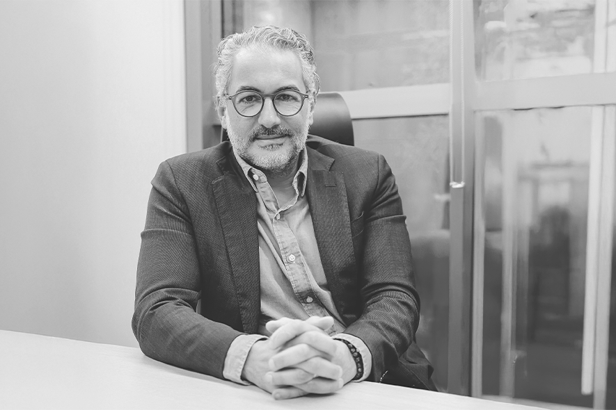 Foto do CEO da SKR, Silvio Kozuchowicz, apoiado em uma mesa de escritório.